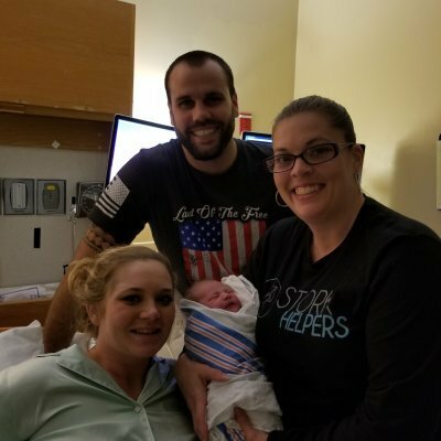 couple with newborn baby and doula