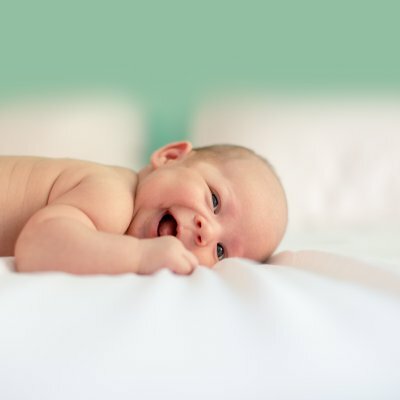 baby smiling laying on blanket