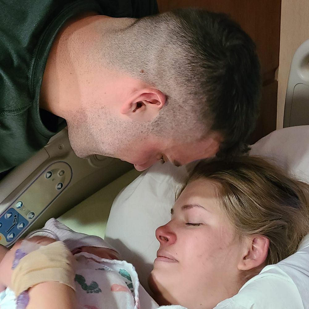couple looking at newborn baby